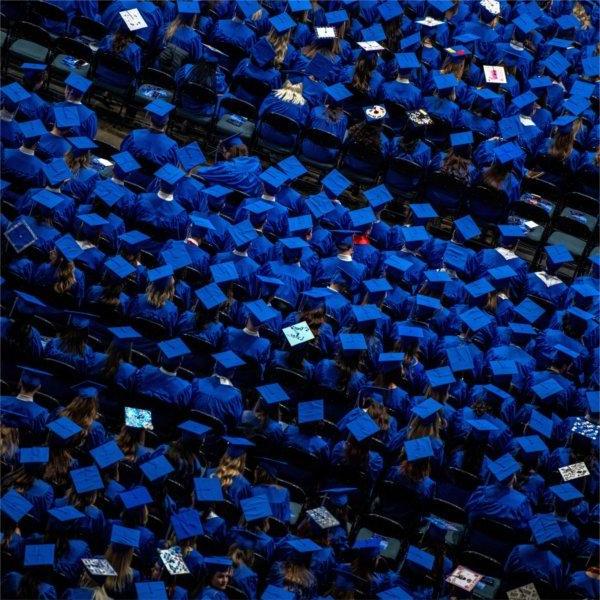 A group of graduates wearing their caps during a ceremony is seen from above.
